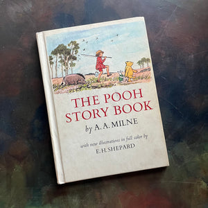 The Pooh Story Book written by A.A. Milne with black and white and color illustrations by E.H. Shepard-classic picture book-read aloud favorite-a log cabin 100 book-view of the front cover with winnie, eyore, Christoper Robin and piglet on the cover walking in a line