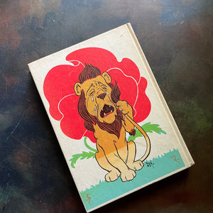 The Wizard of Oz by written by L. Frank Baum with illustrations by W. W. Denslow-1956 Edition-modern day fairy tale-classic children's literature-view of the back cover with an image of the cowardly lion crying