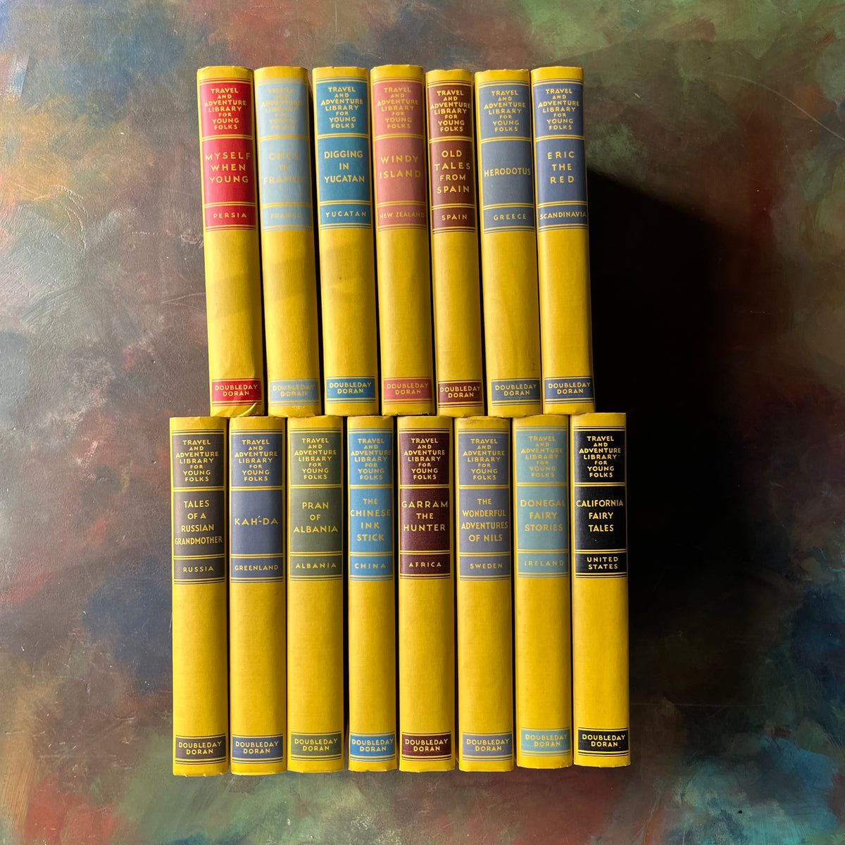 Travel and Adventure Library for Young Folks COMPLETE 15-Volume Set-1930's book set for children-stories around the world-view of the spines in bright yellow & different colors behind the titles