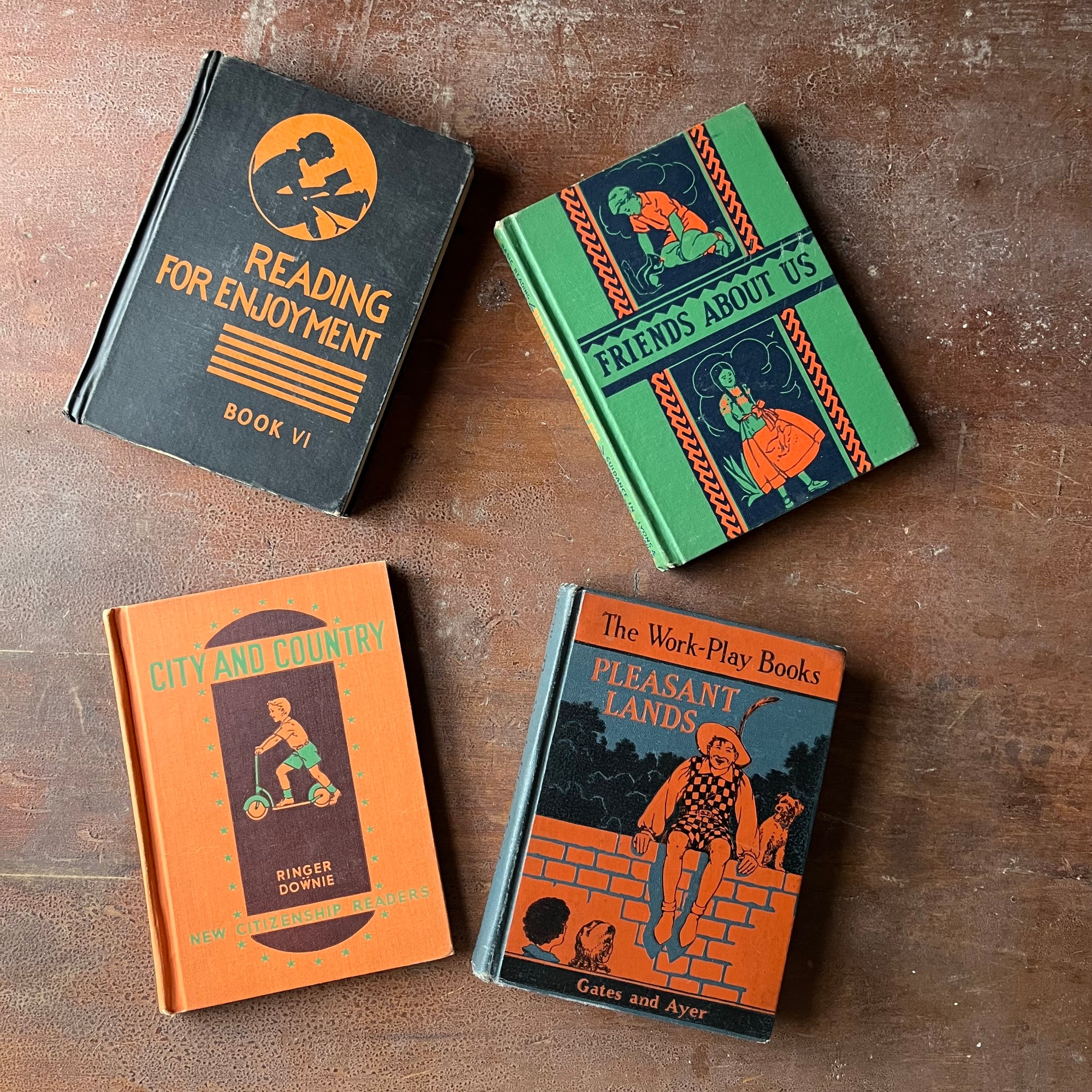 Vintage Schoolbook Set of 4 for Teaching-Learning to Read-Reading for Enjoyment, Friends About Is, City and Country & Pleasant Lands-antiquarian school books-view of the decorative front covers in bright colors - black & orange, green & Blue, orange & green & orange & blue