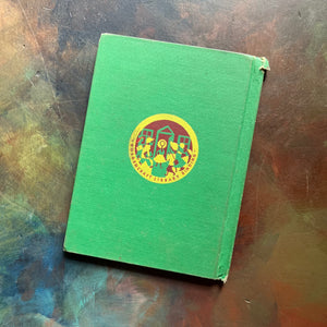 Vintage Green book titled 'Tomorrow the Moon' by Walt Disney on a textured surface-A Tomorrowland Adventure Book-Walt Disney Productions-living science book for kids-view of the back cover