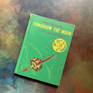 Vintage Green book titled 'Tomorrow the Moon' by Walt Disney on a textured surface-A Tomorrowland Adventure Book-Walt Disney Productions-living science book for kids-view of the front cover