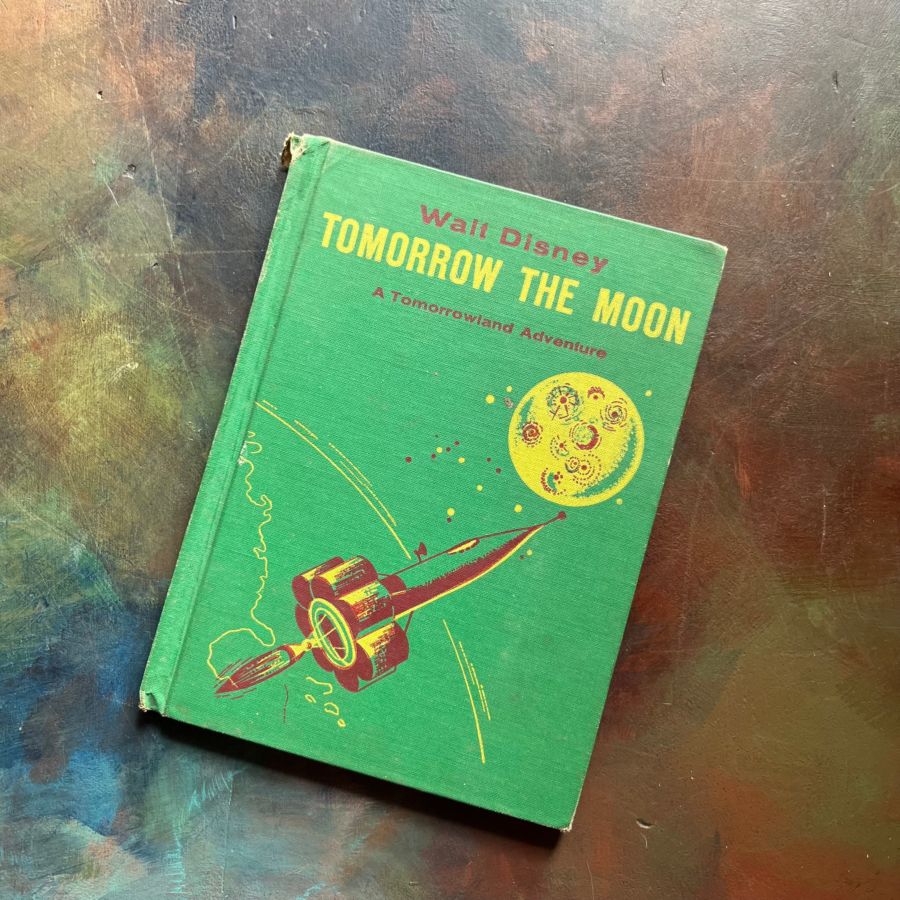 Vintage Green book titled 'Tomorrow the Moon' by Walt Disney on a textured surface-A Tomorrowland Adventure Book-Walt Disney Productions-living science book for kids-view of the front cover