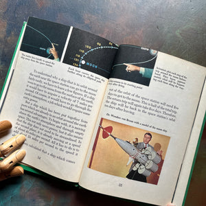 Vintage Green book titled 'Tomorrow the Moon' by Walt Disney on a textured surface-A Tomorrowland Adventure Book-Walt Disney Productions-living science book for kids-view of the illustrations and photographs