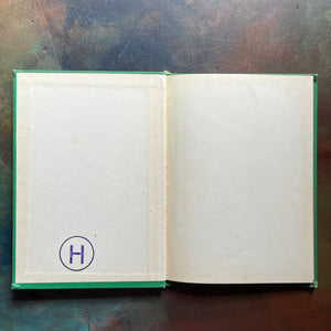 Vintage Green book titled 'Tomorrow the Moon' by Walt Disney on a textured surface-A Tomorrowland Adventure Book-Walt Disney Productions-living science book for kids-view of the inside cover's endpapers