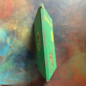 Vintage Green book titled 'Tomorrow the Moon' by Walt Disney on a textured surface-A Tomorrowland Adventure Book-Walt Disney Productions-living science book for kids-view of the spine