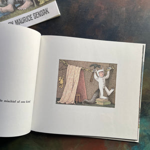 Where The Wild Things Are written and illustrated by Maurice Sendak-50th anniversary edition-2013-caldecott award-winning picture book-view of the first illustration within the story showing Max hammering a clothesline in his room