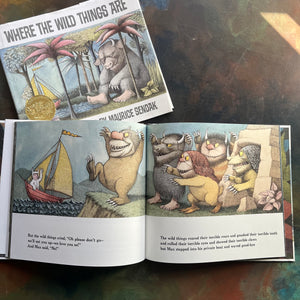 Where The Wild Things Are written and illustrated by Maurice Sendak-50th anniversary edition-2013-caldecott award-winning picture book-view of the monsters waving to Max as he sales away