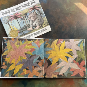 Where The Wild Things Are written and illustrated by Maurice Sendak-50th anniversary edition-2013-caldecott award-winning picture book-view of the inside cover depicting large leaves or treetops in vibrant colors