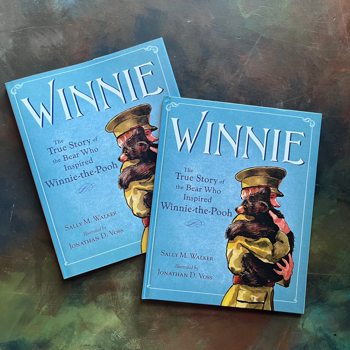 Winnie written by Sally M. Walker with illustrations by Jonahan D. Voss-The True Story of the Bear Who Inspired Winnie-The-Pooh-view of the front cover and dust jacket cover with an image of a soldier carrying a baby bear in his arms
