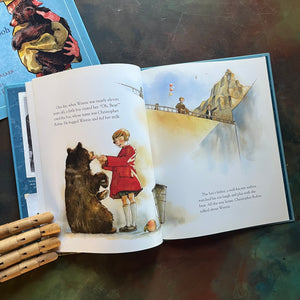 Winnie written by Sally M. Walker with illustrations by Jonahan D. Voss-The True Story of the Bear Who Inspired Winnie-The-Pooh-view of the bear at the zoo and Christopher Robin feeding the bear