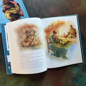Winnie written by Sally M. Walker with illustrations by Jonahan D. Voss-The True Story of the Bear Who Inspired Winnie-The-Pooh-view of A. A. Milne telling Christopher Robin stories in bed with his bear, Winnie, tucked on his lap.