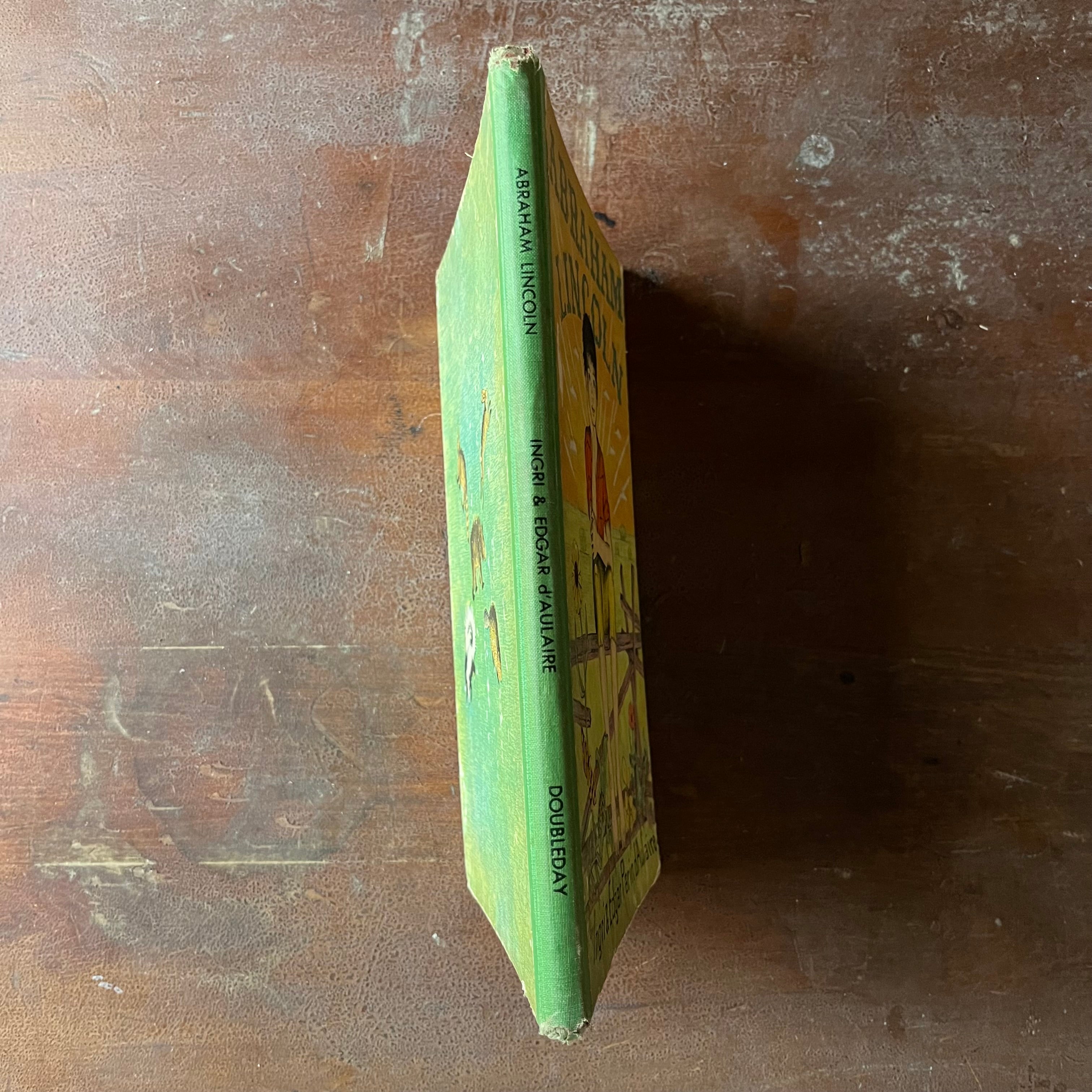 Log Cabin Vintage – vintage children’s book, children’s book, chapter book, living history book, history book, non-fiction, picture book - Abraham Lincoln by Ingri & Edgar Parin d'Aulaire - view of the spine in green with the title, authors & publisher listed in black ink