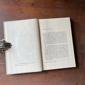 The Black Arrow a 1954 Junior Deluxe Editions Children's Chapter Book sits atop a wood table with the copyright page shown